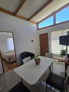 a living room with a white table and chairs at Alto La Florida Cabañas in Huasco