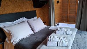 a bedroom with a bed with two pillows at Chalé Container Lufre in Santo Antônio do Pinhal