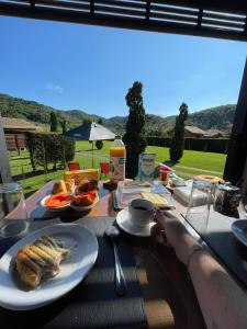a person sitting at a table with a plate of food at Chalé Container Lufre in Santo Antônio do Pinhal