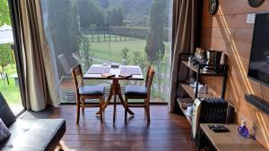 a table and chairs in a room with a large window at Chalé Container Lufre in Santo Antônio do Pinhal