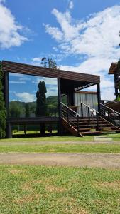 a picnic shelter with a bench in a park at Chalé Container Lufre in Santo Antônio do Pinhal