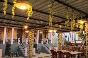 a restaurant with tables and chairs and lights at Montavilla Eden Homestay Sittong in Kurseong