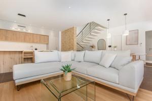 a living room with a white couch and a glass table at Villa Kamelicina in Vinišće