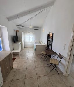 a large room with a kitchen and a table and chairs at Οικία Χωρας Κυθνου in Kithnos