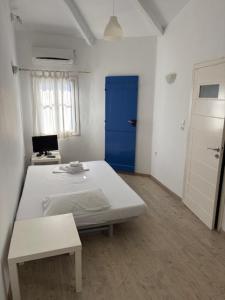 a room with a white table and a blue door at Οικία Χωρας Κυθνου in Kithnos