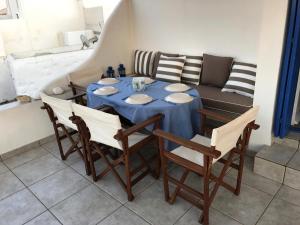 a dining room table with chairs and a couch at Οικία Χωρας Κυθνου in Kithnos