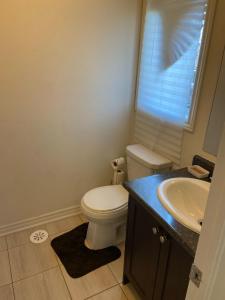 a bathroom with a white toilet and a sink at Comfortable Room with Free Parking in Brampton