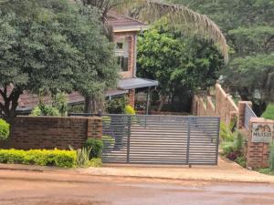 a house with a gate in front of a house at Milasha Guest House in Louis Trichardt