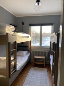 a bedroom with two bunk beds and a window at Lillskarvens vandrarhem in Funäsdalen