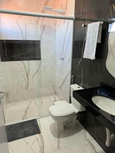 a bathroom with a toilet and a sink and a shower at Pousada nascer do sol in Portalegre