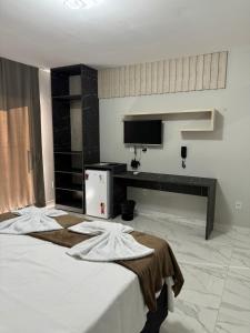 a bedroom with a bed and a tv on the wall at Pousada nascer do sol in Portalegre