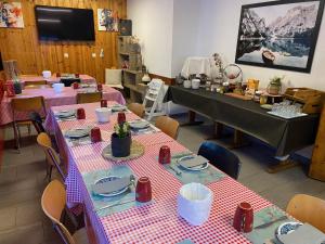 a dining room with tables with red and white checkered table cloth at Séjour Edelweiss in Arolla