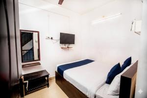 a bedroom with a bed and a mirror and a tv at Starlight Hotel1Square in Pondicherry