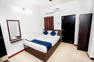 a hotel room with a bed and a mirror at Starlight Hotel1Square in Pondicherry +3 photos