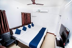 a small bedroom with a bed and a television at Starlight Hotel1Square in Pondicherry
