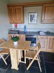 a kitchen with a wooden table and chairs in it at Huntshaw Stables in Earlston