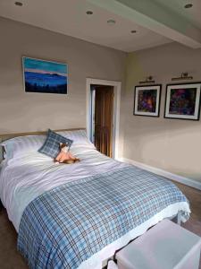 a bedroom with a bed with a teddy bear on it at Huntshaw Stables in Earlston