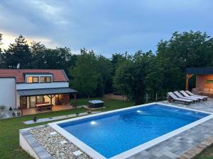a swimming pool in the backyard of a house at Villa BELEVITA odmor u prirodi sa grijanim bazenom in Čepelovac