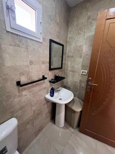 a bathroom with a sink and a toilet and a mirror at Villa 2 in Al Maqārisah