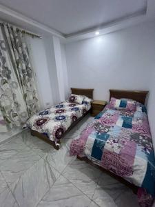 a bedroom with two beds in a room at Villa 2 in Al Maqārisah