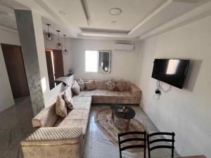 a living room with a couch and a tv at Villa 2 in Al Maqārisah