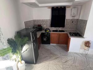 a small kitchen with a stove and a refrigerator at Villa 2 in Al Maqārisah