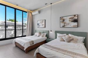 a bedroom with two beds and a large window at Beachfront Modern Villa with Pool AZURE in Punta Rucia