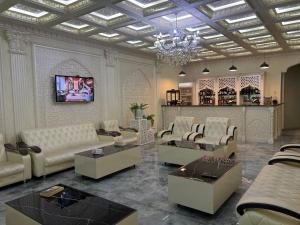 a living room with white furniture and a chandelier at Ideal Hotel in Samarkand