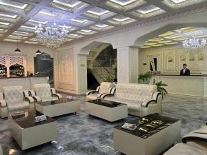 a living room with couches and a chandelier at Ideal Hotel in Samarkand
