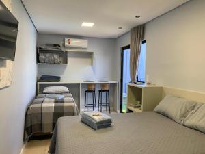 a bedroom with two beds and a kitchen with a bar at Pousada Selenita in Ametista do Sul +24 photos