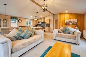 a living room with two couches and a kitchen at Sandy Lane 18 - Lodge with Hot Tub in Allerthorpe