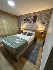 a bedroom with a large bed and a brick wall at Hôtel Le Prince, Poitiers Gare in Poitiers +3 photos