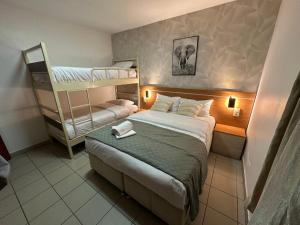 a bedroom with a bed and bunk beds in it at Hôtel Le Prince, Poitiers Gare in Poitiers