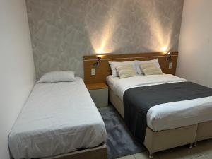 two beds in a hotel room with two bedsvisor at Hôtel Le Prince, Poitiers Gare in Poitiers
