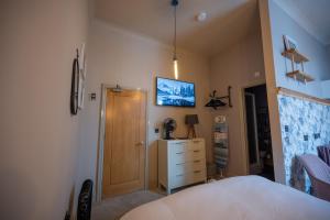a bedroom with a bed and a television on the wall at The Pheasant in Broseley