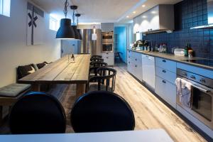 a kitchen with a wooden table and black chairs at Lillskarvens vandrarhem in Funäsdalen