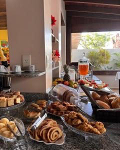 a table with many different types of bread and pastries at Hotel Master Cuiabá in Cuiabá
