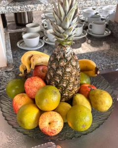 a plate of fruit on a counter with a pineapple at Hotel Master Cuiabá in Cuiabá
