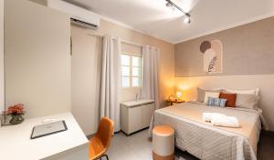 a small bedroom with a bed and a desk at Casa completa 2 Quartos, garagem privativa e Self check-in -Ideal para famílias, casais e profissionais em trabalho remoto in Campo Grande