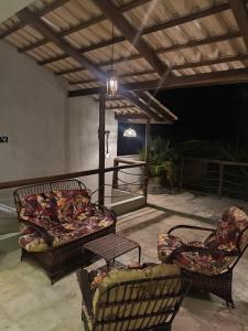 two chairs and a couch on a patio at night at Rekanto Sabiá in Jijoca de Jericoacoara