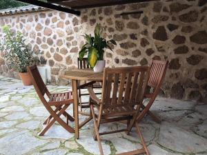 a wooden table with two chairs and a plant at Las Casitas de Layos in Layos