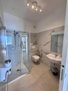 a bathroom with a shower and a toilet and a sink at Lido Di Alghero Beach Resort in Alghero +51 photos