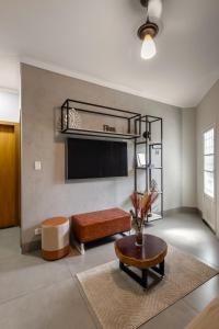 a living room with a tv and a couch and a table at Casa completa 2 Quartos, garagem privativa e Self check-in -Ideal para famílias, casais e profissionais em trabalho remoto in Campo Grande