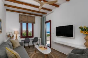 a living room with a couch and a tv at Glaucus Summer House sea view in Mandrakia