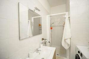 a white bathroom with a sink and a mirror at La madonnuccia in Deruta