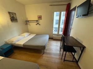ein Schlafzimmer mit Bett, Schreibtisch und Fernseher in der Unterkunft Hotel Chevallier in Levallois-Perret