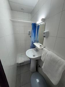 ein kleines Badezimmer mit Waschbecken und Toilette in der Unterkunft Hotel Chevallier in Levallois-Perret