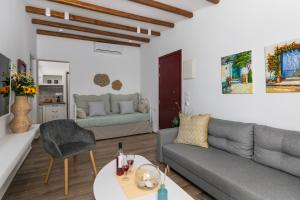 a living room with a couch and a table at Glaucus Summer House sea view in Mandrakia