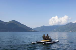zwei Personen sitzen in Kanus auf einem großen Gewässer in der Unterkunft Hotel Eden Roc - The Leading Hotels of the World in Ascona