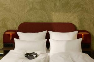 a bed with two white pillows and a headboard at The Cloud One Frankfurt-Metropolitan in Frankfurt +55 photos